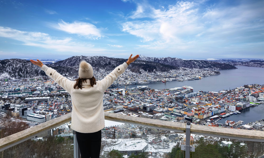 Touristin genießt die Winterlandschaft mit Blick auf das Stadtbild von Bergen in Norwegen